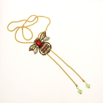 Jeweled bee bolo tie with ruby-red body, sparkling wings, and gold cord, handmade western jewelry from Texas.